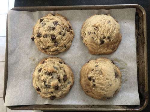 Freshly baked chocolate chip cookies on a baking sheet